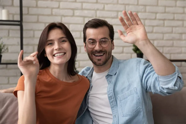 Smiling couple greet talking on video call at home — Stock Photo, Image