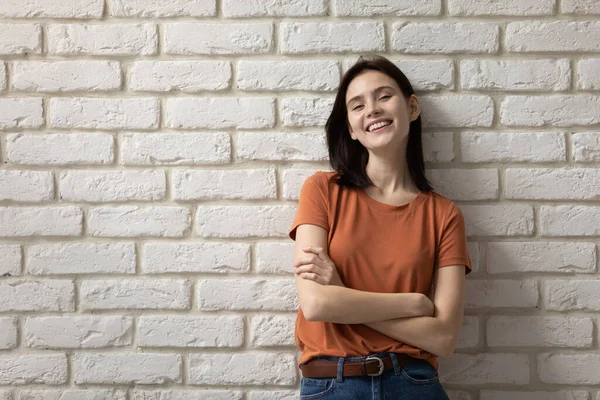 Porträtt av leende vit flicka poserar nära tegelvägg — Stockfoto