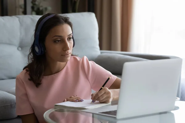 Giovane donna etnica in cuffia studiare online a casa — Foto Stock