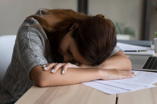 Trött ung kvinna somnar vid bordet arbetsplatsen — Stockfoto