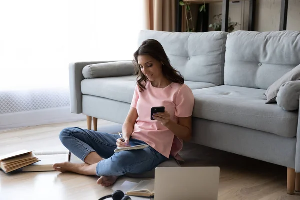 Етнічна дівчина сидить на підлозі навчається онлайн вдома — стокове фото