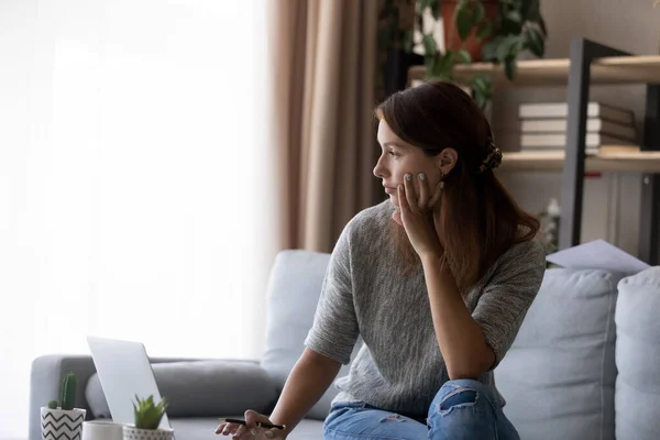 Pensive woman work on laptop look in distance thinking — Stock Photo, Image