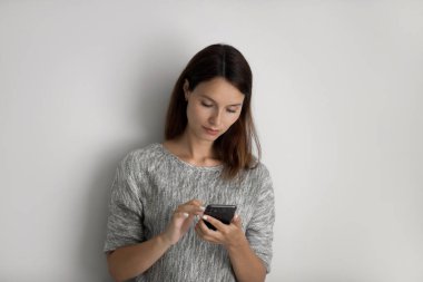 Düşünceli beyaz kadın akıllı telefonda kablosuz internet kullanıyor.