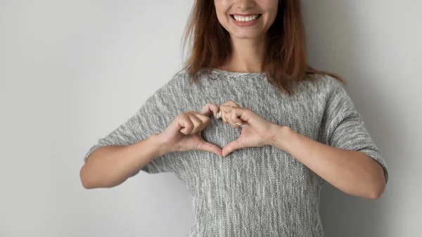 Крупним планом усміхнена жінка показує жест серця — стокове фото