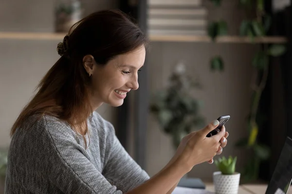 Улыбающаяся молодая женщина использовать смартфон гаджет просмотра Интернета — стоковое фото