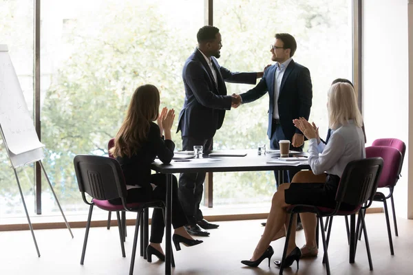 African leader promoting caucasian employee on corporate meeting — Stock Photo, Image