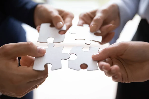 Diverse businesspeople collecting puzzle showing successful teamwork — Stock Photo, Image