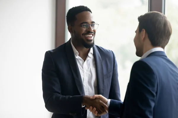 Diverse business partners handshaking being satisfied with a deal — Stock Photo, Image
