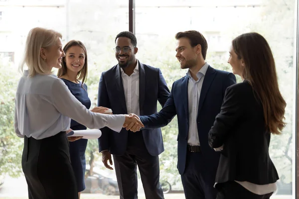 Young team leader greeting elder female employee at lunch break — Stock Photo, Image