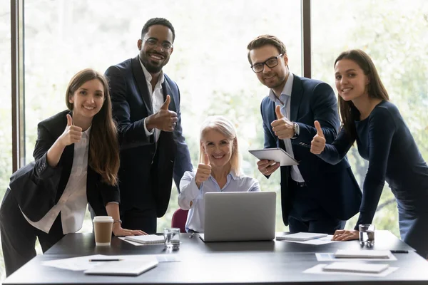 Grupo multiétnico de empresários sorridentes mostrando polegares para cima — Fotografia de Stock