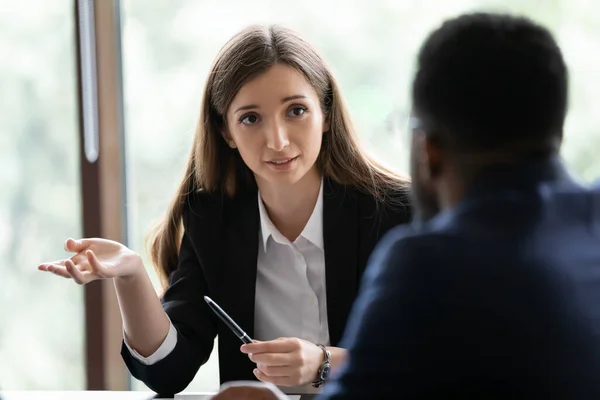 Reclutador femenino amistoso que hace preguntas al solicitante de empleo afroamericano masculino — Foto de Stock