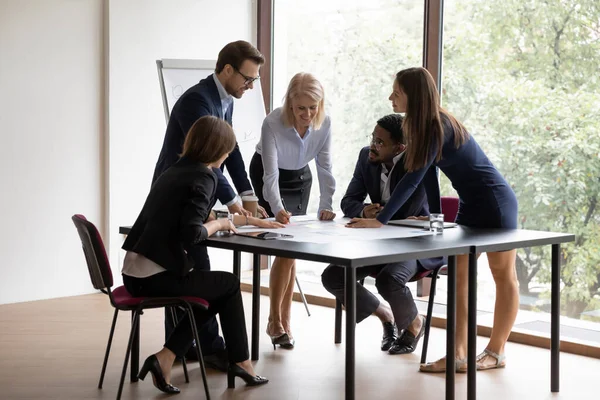 Mujer de negocios envejecida ayudando a los jóvenes colegas a cumplir con la tarea — Foto de Stock