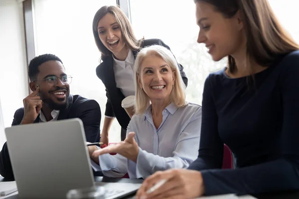 Elder female mentor teaching interns to create project on laptop — Stock Photo, Image
