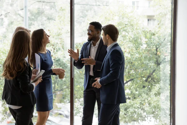 Vänliga multiraciala kollegor chattar på fikapaus — Stockfoto