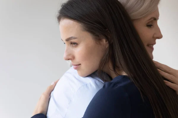 Grown daughter seeking support in arms of her senior mother — Stock Photo, Image