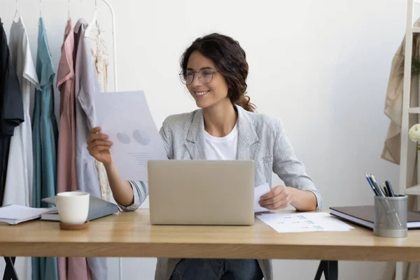 Sorrindo jovem empresária analisando as vendas no escritório moderno. — Fotografia de Stock