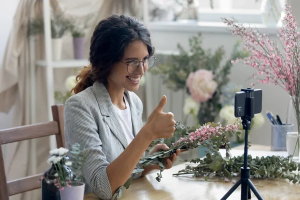 Lachende mooie jonge professionele decorateur tonen duimen omhoog gebaar. — Stockfoto