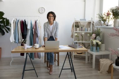 Çekici gülümseyen genç moda tasarımcısının portresi.