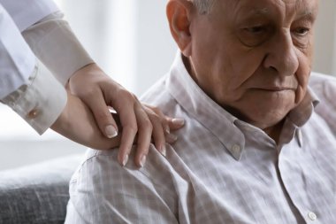 Merhametli genç bayan doktor, depresyondaki yaşlı hastayı destekliyor..