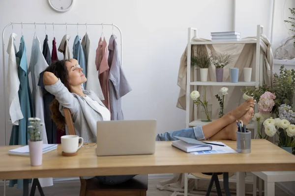 Jovem empresária criativa relaxante com as pernas na mesa. — Fotografia de Stock