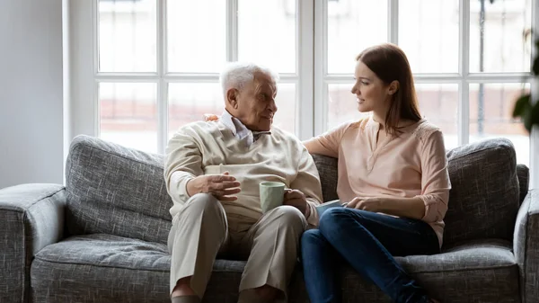 Usmívající se starší osmdesátník muž mluví s dospělou dcerou. — Stock fotografie