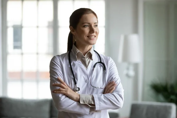 Dromerig jong gelukkig positief vrouwelijke arts denken van professionele uitdagingen. — Stockfoto