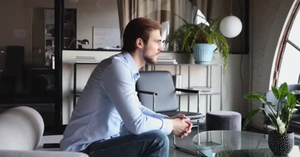 Jeune homme d'affaires concentré en attente d'un partenaire au bureau. — Video