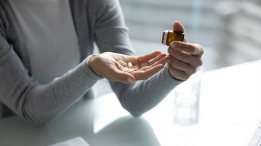 Şişeden hap alan genç bayanı kapatın.