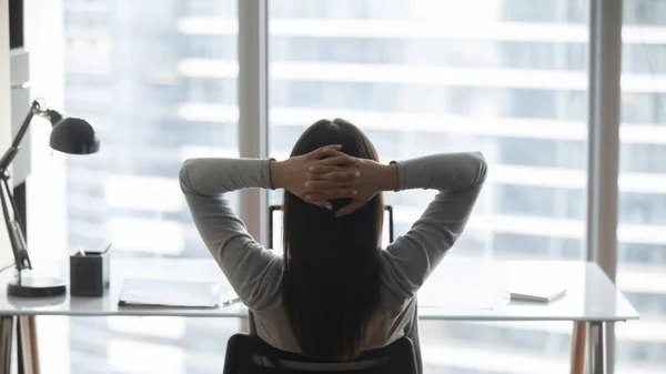 Vista trasera joven mujer de negocios inclinada hacia atrás en silla cómoda — Foto de Stock