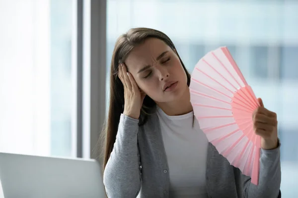 Giovane donna d'affari infelice surriscaldata che agita ventilatore di carta in ufficio — Foto Stock