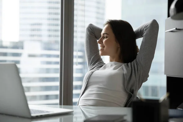 Soñadora mujer de negocios sonriente relajándose en silla de oficina, mirando a un lado —  Fotos de Stock