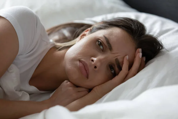 Close up estressado jovem deitado na cama sozinho — Fotografia de Stock