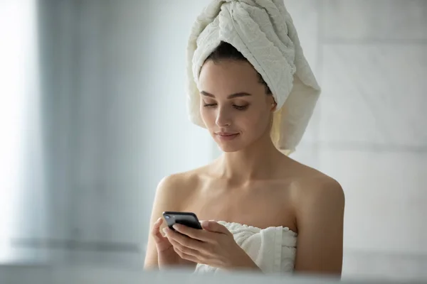 Gros plan tête tourné femme en utilisant smartphone dans la salle de bain — Photo