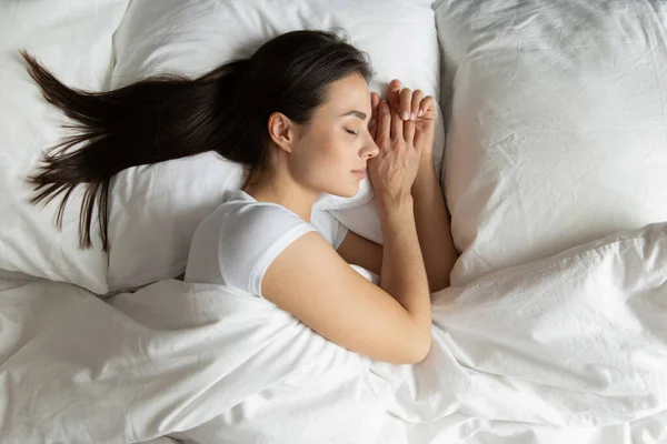 Vista dall'alto bella giovane donna che dorme in un letto accogliente — Foto Stock