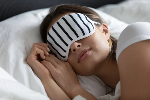 Close up peaceful young woman wearing stripped mask sleeping — Stock Photo, Image