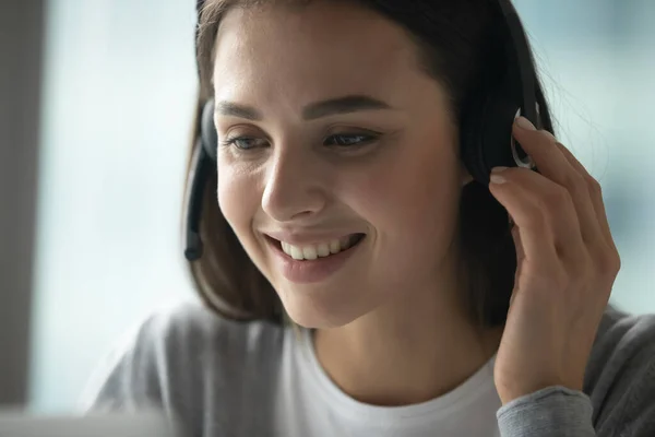 Close up smiling young woman employee wearing headset speaking — Stock Photo, Image