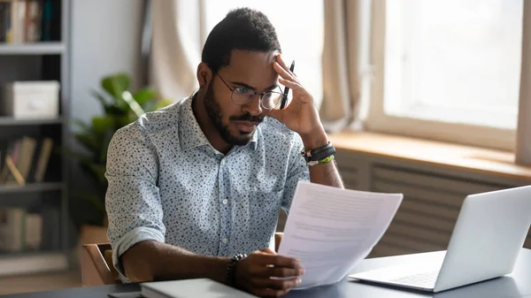 Stressed dissatisfied African American man reading letter with bad news — Stock Photo, Image