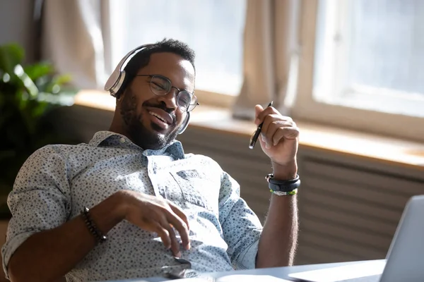 Satisfeito relaxado afro-americano homem usando fones de ouvido apreciando música — Fotografia de Stock