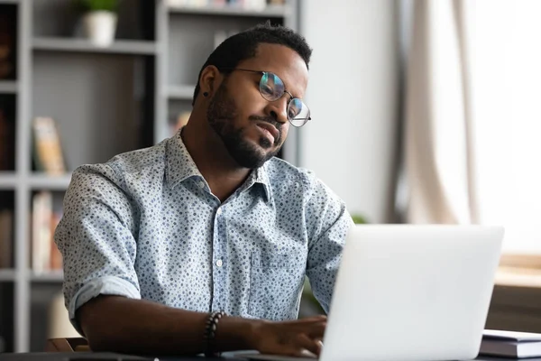 Perezoso empresario afroamericano desmotivado mirando la pantalla del ordenador portátil — Foto de Stock