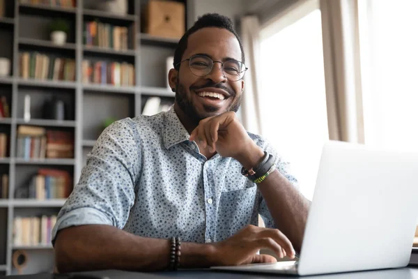 Huvudskott porträtt skrattar afroamerikansk affärsman sitter vid skrivbordet — Stockfoto
