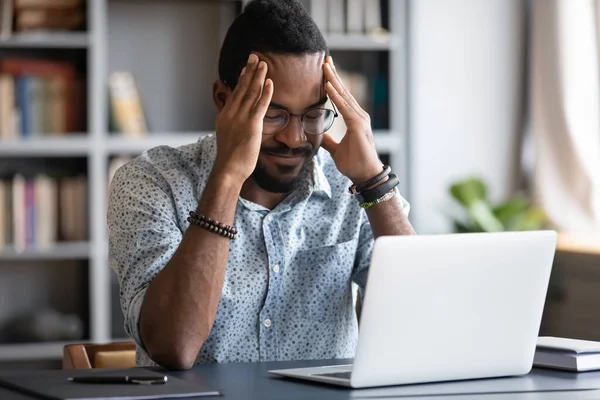 Stressed African American businessman touching temples, suffering from headache — Stock Photo, Image