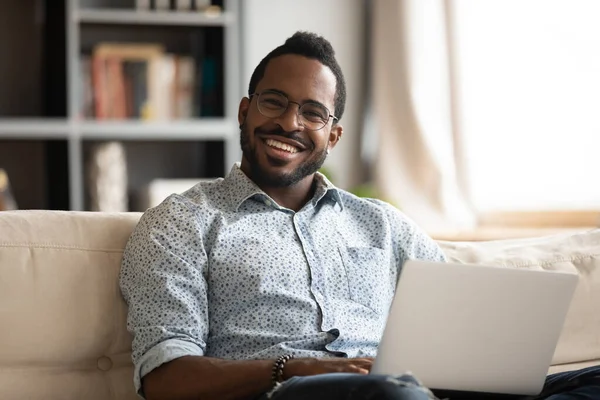 Head shot portrait smiling African American man relaxing with laptop — Stock Photo, Image