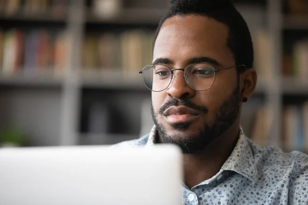 Primer plano serio hombre afroamericano mirando la pantalla de la computadora — Foto de Stock