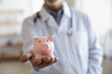 Üniformalı, pembe kumbaralı olgun bir doktor.