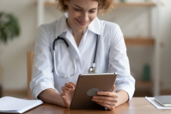 Primer plano sonriente mujer médico usando tableta digital en el hospital —  Fotos de Stock