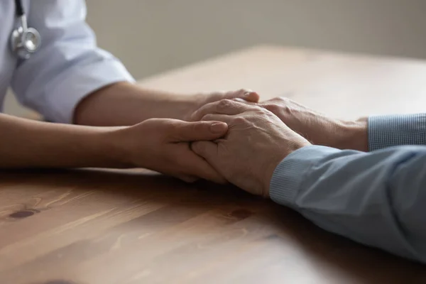 Primer plano cuidador consolando anciano viejo paciente, cogido de la mano — Foto de Stock