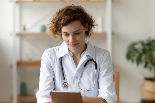 Primer plano centrado mujer confiada médico utilizando tableta digital —  Fotos de Stock