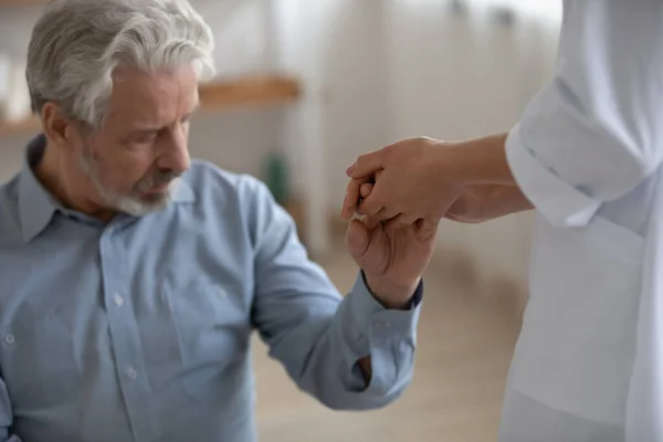 Nahaufnahme Krankenschwester Pflegekraft hält einsam reifen Patienten Hand — Stockfoto