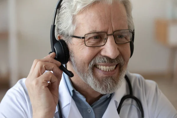 Close-up lachende senior arts dragen headset werken online — Stockfoto