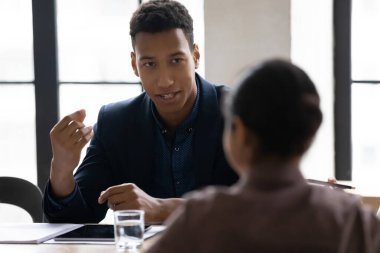 Genç Afrikalı Amerikalı yönetici Hintli meslektaşıyla proje fikirlerini paylaşıyor..
